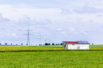 Chicken coop on a green field with solar cells and a sign with German text fresh eggs from domestic free range