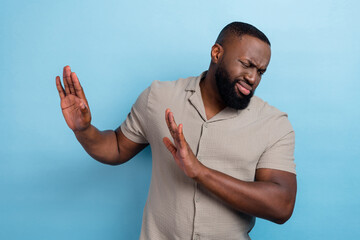 Portrait of handsome unsatisfied person arms palms block empty space isolated on blue color...