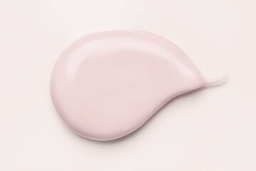 Pink smear of cosmetic clay or cream on a pastel background.