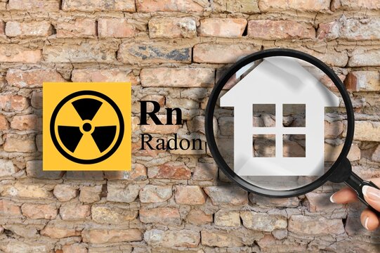 The danger icon and home.  Concept  radioactive warning symbol and home silhouette seen through a magnifying glass.