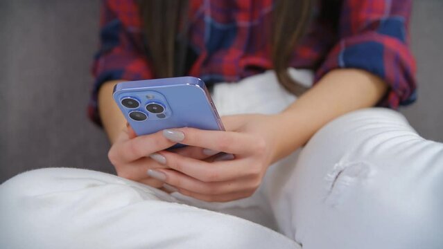 Person swiping to the left on smartphone. Young woman browsing mobile app on a modern telephone