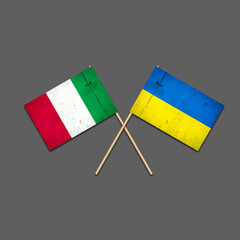Flags of Italy and Ukraine, on wooden sticks. Isolated on a gray background. International political relations. Commonwealth. Support. Political Economic