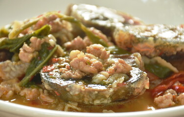 slice boiled  black preserved egg dressing spicy fried chop pork and basil leaf on plate
