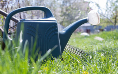 Blue plastic pot for watering in the garden. Can water. Watering can for flowers on the street, in the garden or garden on a warm summer sunny day. © Yevhen Roshchyn