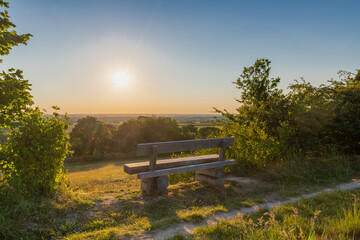 A beautiful sunset late Spring over the rolling hills from south Limburg. The wooden bench is an idyllic place for couples to enjoy a romantic evening overlooking to landscape.