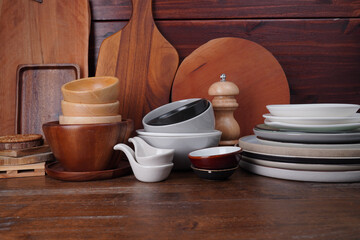 Fototapeta na wymiar Kitchen accessories Cups, plates, bowls, chopping boards and wooden cups, on a wooden table