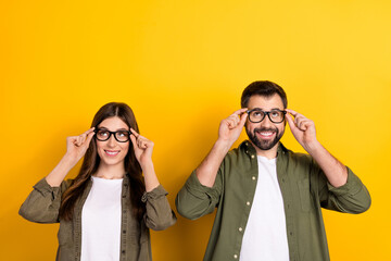 Photo of positive intelligent woman and man wear eyeglasses look up see promotion ad isolated on...