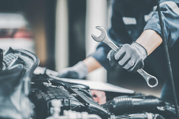 Mechanic works on the engine of the car in the garage. Repair se