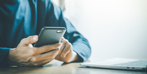 Man holding and using smartphone for sms messages, hipster man typing touchscreen cell phone in the cafe. business, lifestyle, technology and Social media network concept.