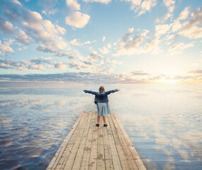 Fototapeta premium Small girl enjoying summer vacation. Happy child, sea, sky and clouds