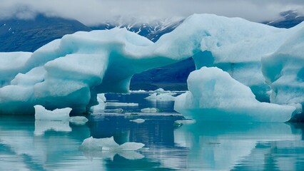 Gletscher Fjord und Gletscher Lagune. Kleine Eisstücke und riesige Eisberge - alles mit bewölktem...