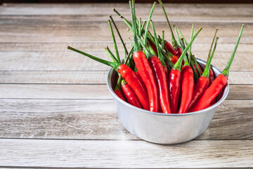 Red chili in a bowl on a wooden table