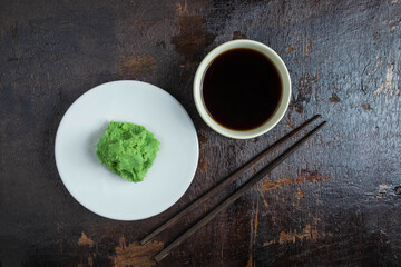 Soy sauce and wasabi on a wooden background