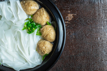 Noodles with meatballs on a wooden table