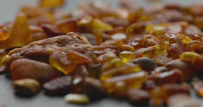Natural amber Stone falling on a wooden plate