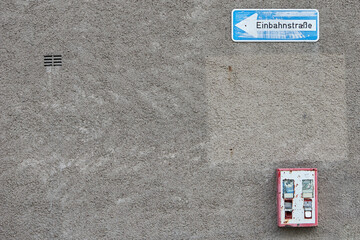 vintage gumball machine fixed on a wall and a German one way sign