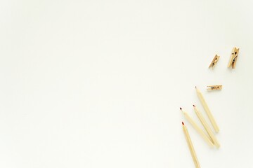 Minimal workspace flat lay composition with pencils and wooden clips, space for text, art, coloring pages design, white background.