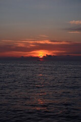 Sunset by the sea scenery, reflections on ripply water surface