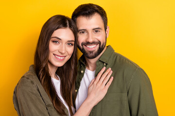 Photo of positive partners embrace beaming smile look camera isolated on yellow color background