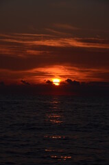 Obraz premium Sunset by the sea scenery, reflections on ripply water surface