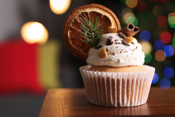 Beautifully decorated Christmas cupcake on wooden table indoors, closeup. Space for text