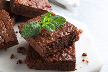 Delicious chocolate brownies with fresh mint on table, closeup