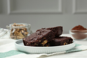 Delicious chocolate brownies with nuts on white table