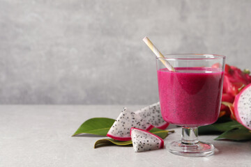 Delicious pitahaya smoothie and fresh fruits on light grey table, space for text