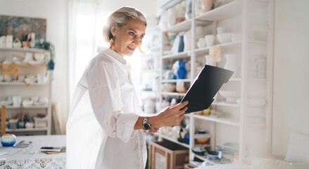 Businesswoman with clipboard working at art studio