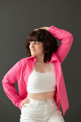 oung happy girl with crooked teeth and cute facial expression with voluminous curly hair poses in...