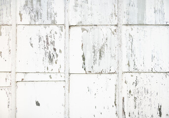 Glazing made of old square shaped glass in a wooden frame with peeling white paint