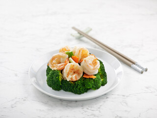 Stir-fried Prawns with Broccoli served in a dish with chopsticks side view on grey background