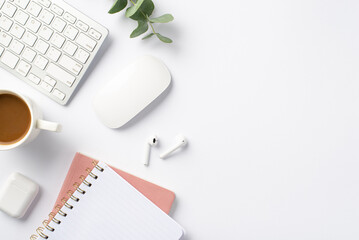 Business concept. Top view photo of workplace keyboard computer mouse eucalyptus cup of coffee wireless earbuds and pink notepads on isolated white background