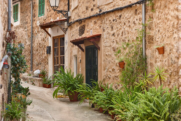Traditional stone alley decorated with plants in Mallorca, Spain
