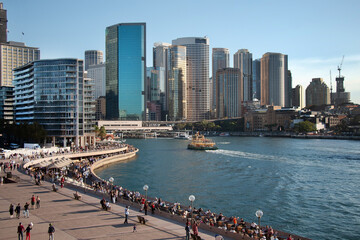 Fototapeta premium Cityscape, Sydney harbor, swarming with crowds of people and a line of skyscrapers, Australia