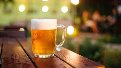Mug of fresh light beer on the outdoor terrace table