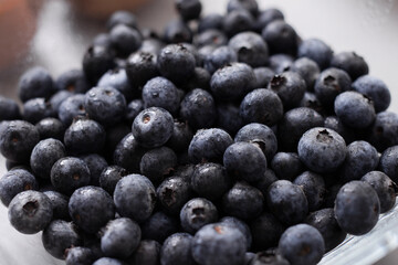 Fresh blueberries in glass bowl on kitchen counter, healthy food for diet.