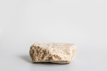 Fototapeta na wymiar Natural stone stand for presentation and exhibitions on pastel gray background. Abstract podium for organic cosmetic products. Minimal style. Selective focus