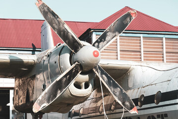 a big old stripped propeller and part of an airplane on the background of a house
