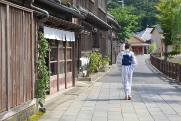 Fototapeta na wymiar 小江戸佐原の町並みを歩く浴衣を着た若い女性の後ろ姿