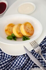 A portion of three round curd cheese pancakes on a white plate. Healthy breakfast. Food background. Copy space.
