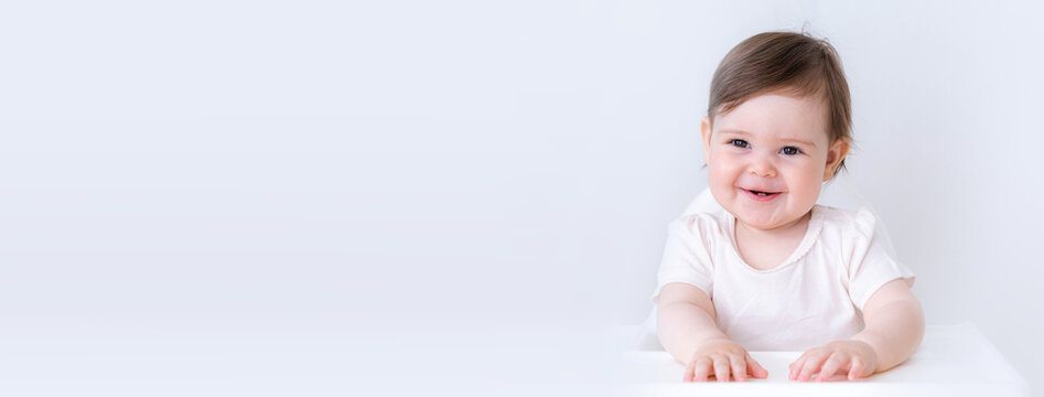 Banner portrait of smiling curious baby child sitting on highchair with copyspace. 