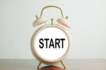 start business,new job,education,new target,career concept.,START word on pink clock over white wall background.
