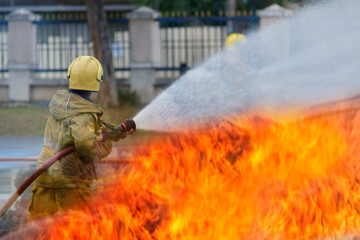 fire fighter Using water mist fire extinguishers to combat oil flames to control fire from...