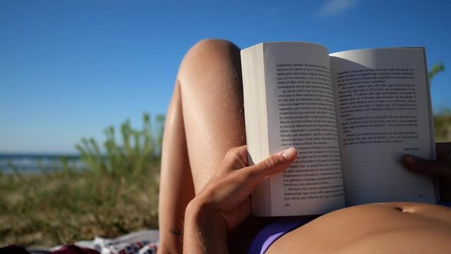woman reading a book on the beach