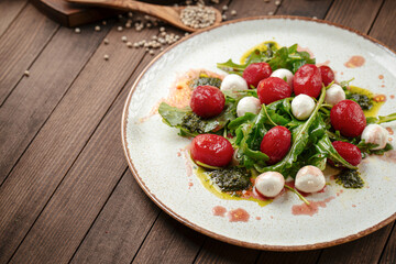 Cherry tomato and mozzarella cheese salad on wooden background