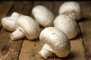 Champignon mushrooms on a wooden background. Delicious and healthy vegetable. Vegetarian food