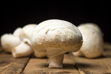 Champignon mushrooms on a wooden background. Delicious and healthy vegetable. Vegetarian food