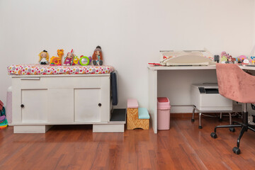 Stretcher with toys in a pediatric office, with a desk and a modern scale for babies