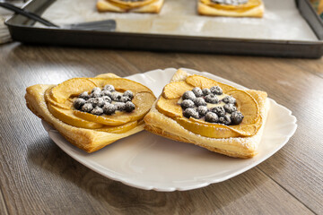puff pastry with blueberry and apple on a wooden background. food concept